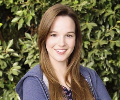 Kay Panabaker in a blue jacket posesfor a picture.